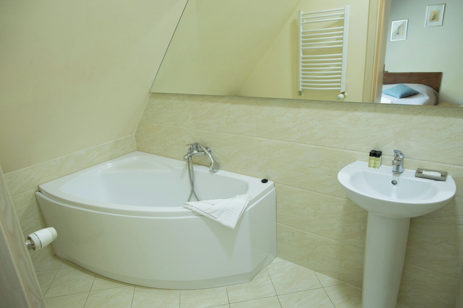 Een badkamer met een vrijstaand bad, een wastafel en een spiegel.