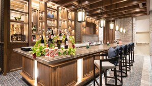 Eine Bar mit einer langen Theke, Holzschränken und Barhocker.