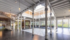 Un vaste atrium doté d’un magnifique escalier, de hauts plafonds et de colonnes richement décorées.