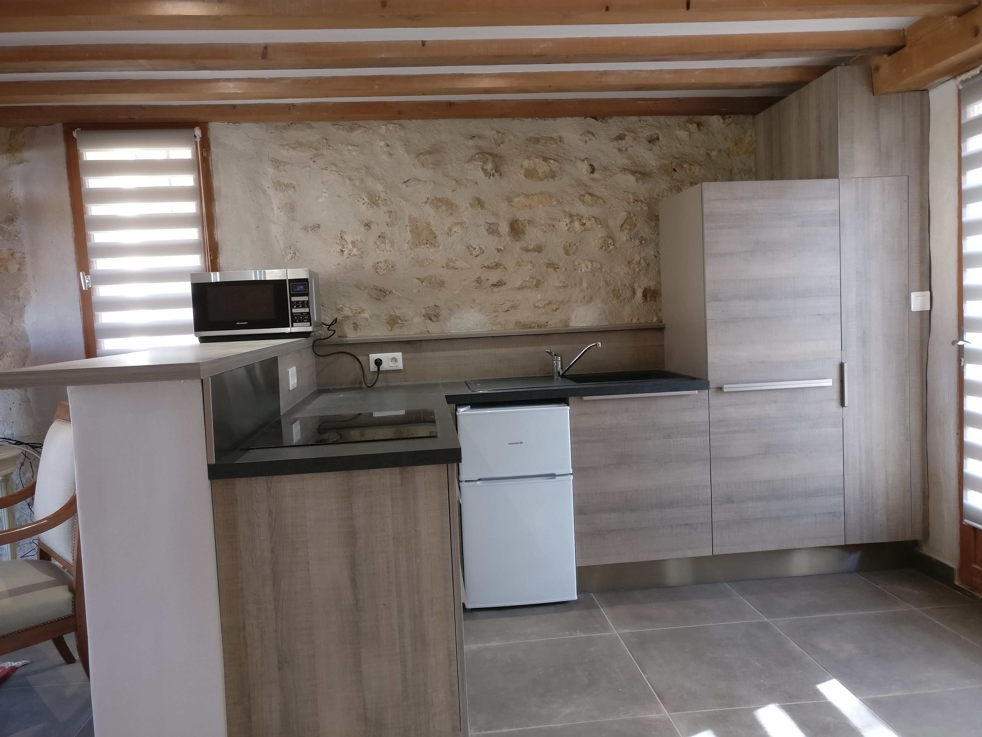A compact kitchen with a built-in microwave, a sink, and a refrigerator.