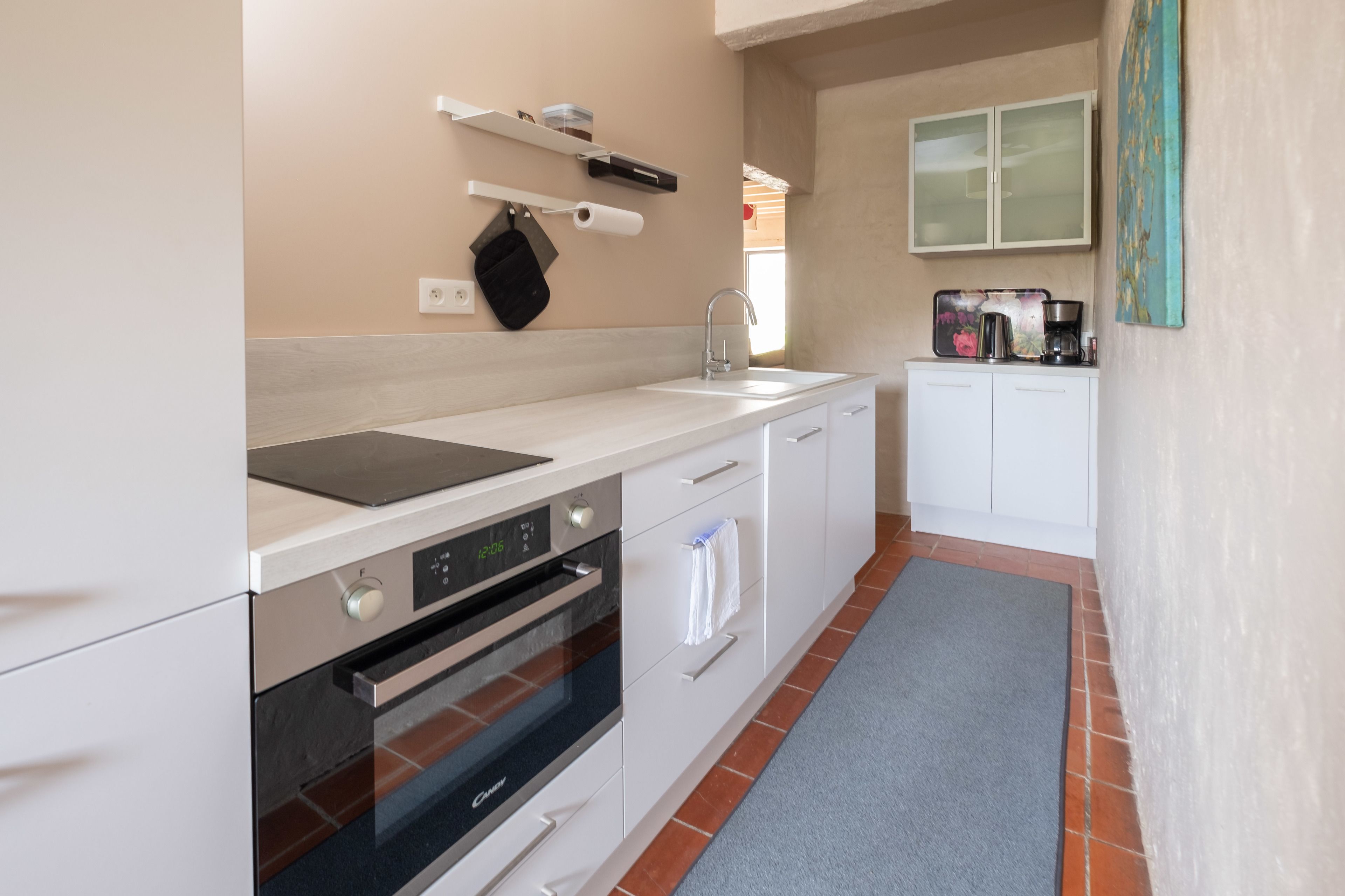 A modern kitchen with white cabinets, a built-in oven, and a countertop.