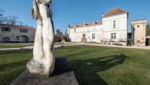 Una escultura en un patio con un edificio al fondo.