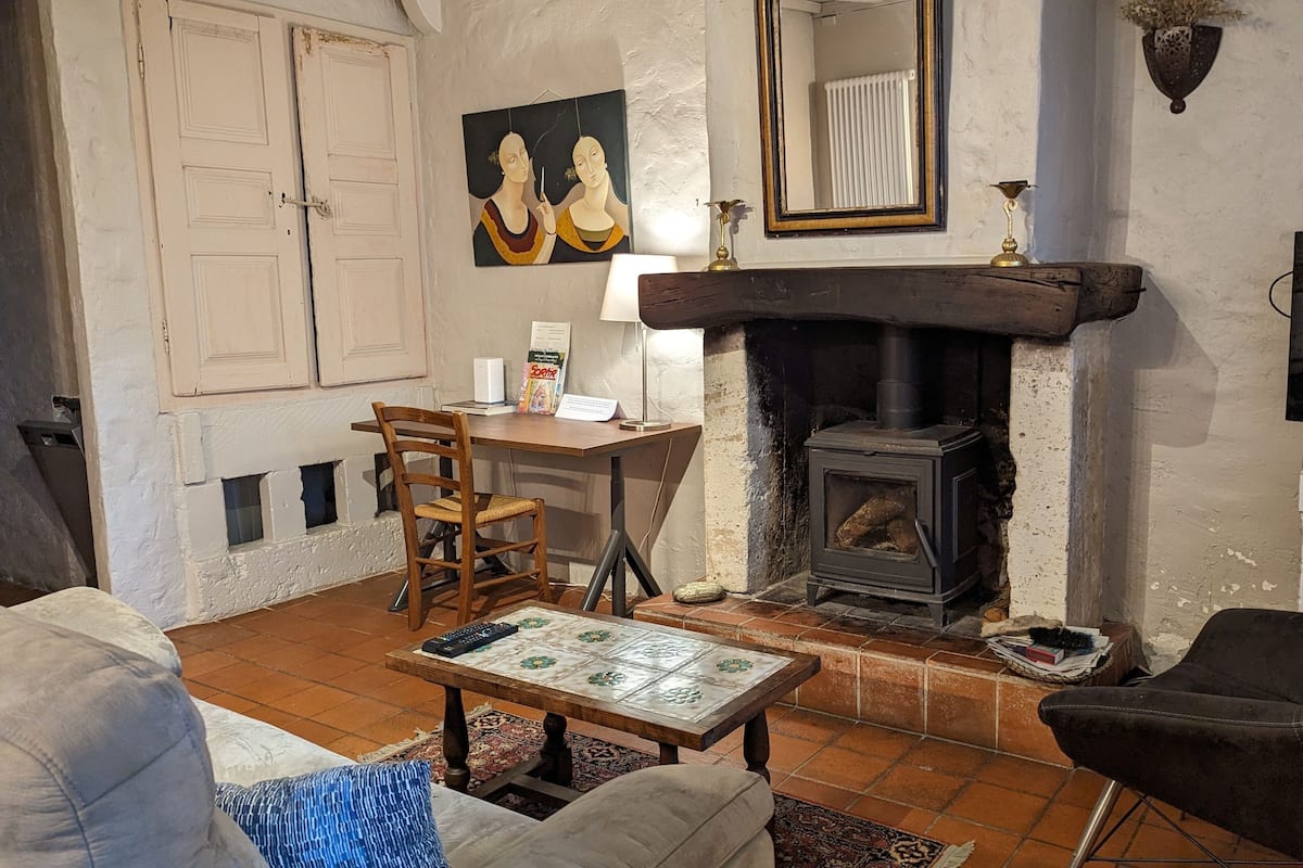 A cozy living room with a fireplace, a television, and a dining area.