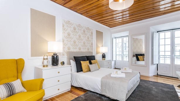 A modern bedroom with a bed, a yellow armchair, and a large window. - LxWay Poiais de São Bento (Lisbon)