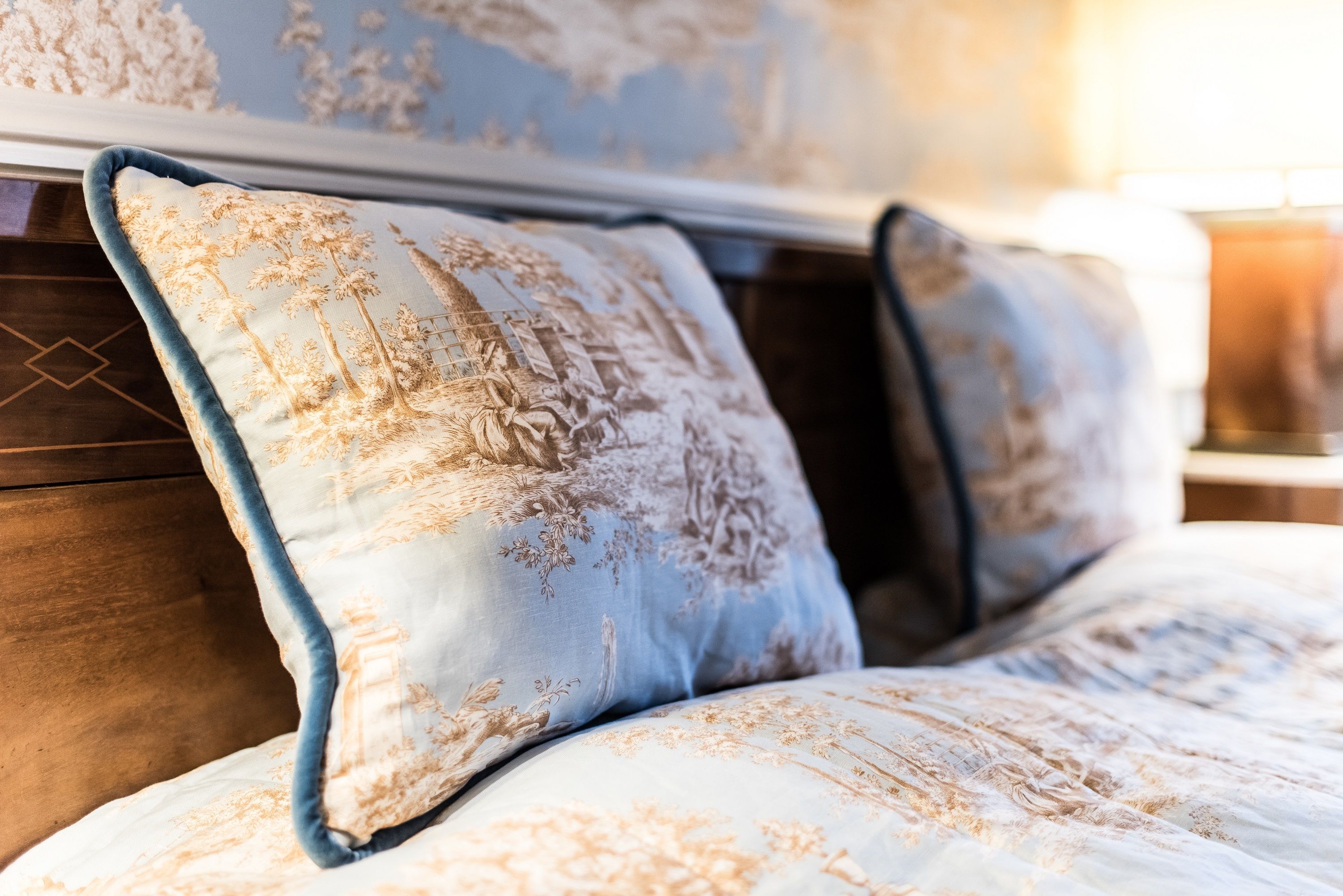 A bed with a floral patterned duvet and matching pillows.