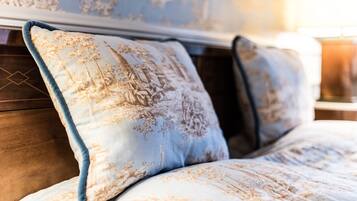 A bed with a floral patterned duvet and matching pillows.