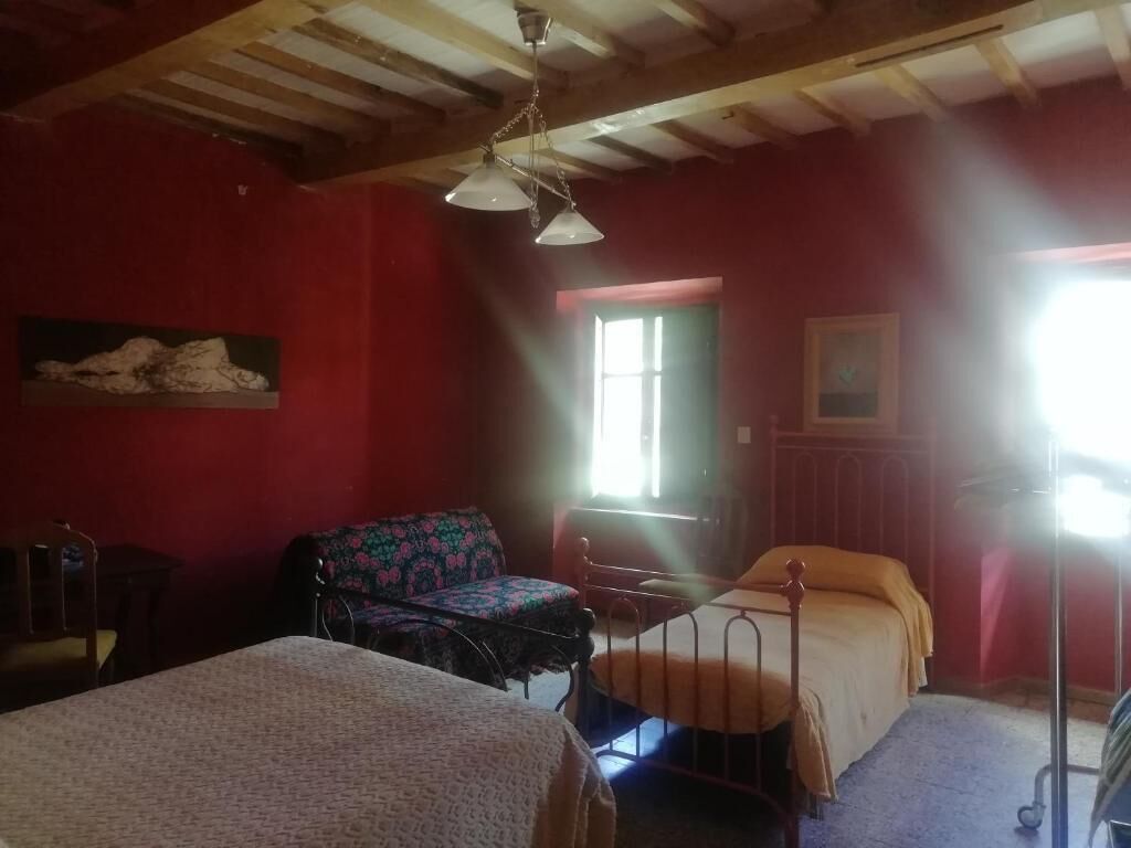 Une pièce comprenant un lit, une chaise, une table et une fenêtre.