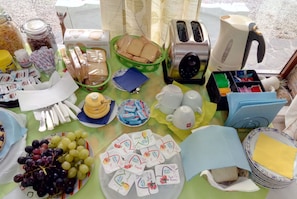 Ein Tisch mit verschiedenen Speisen, darunter Sandwiches, Obst und verpackten Waren.