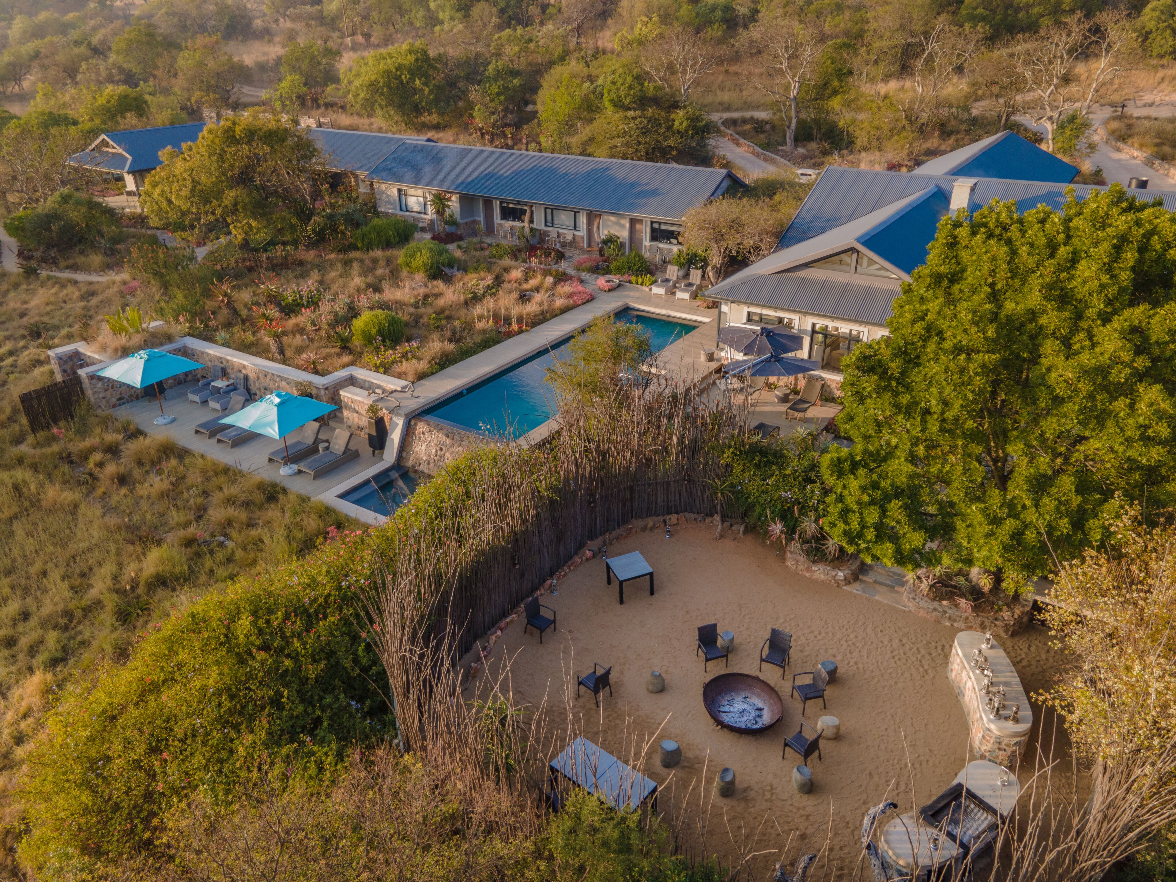 A resort with a swimming pool, outdoor seating, and a fire pit.