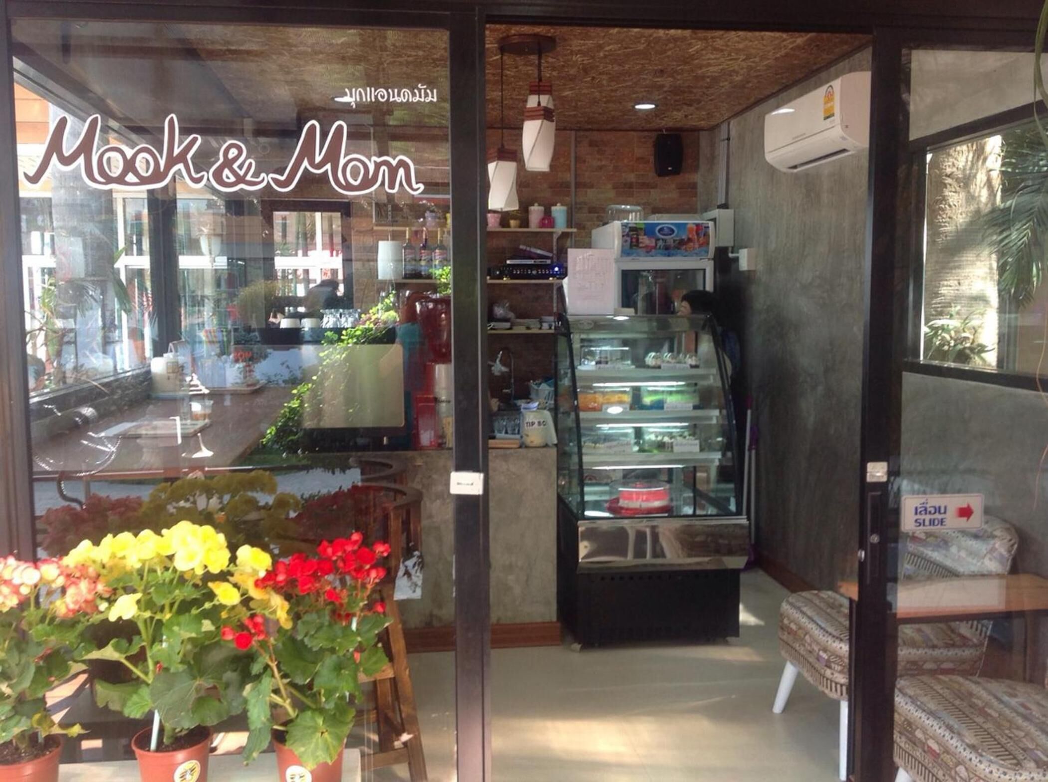 Une vitrine en verre exposant une variété d’articles, avec une enseigne indiquant « Mock & Mom ».
