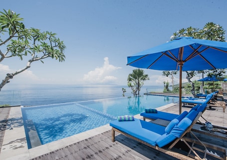 Una piscina al aire libre, sillones reclinables de piscina