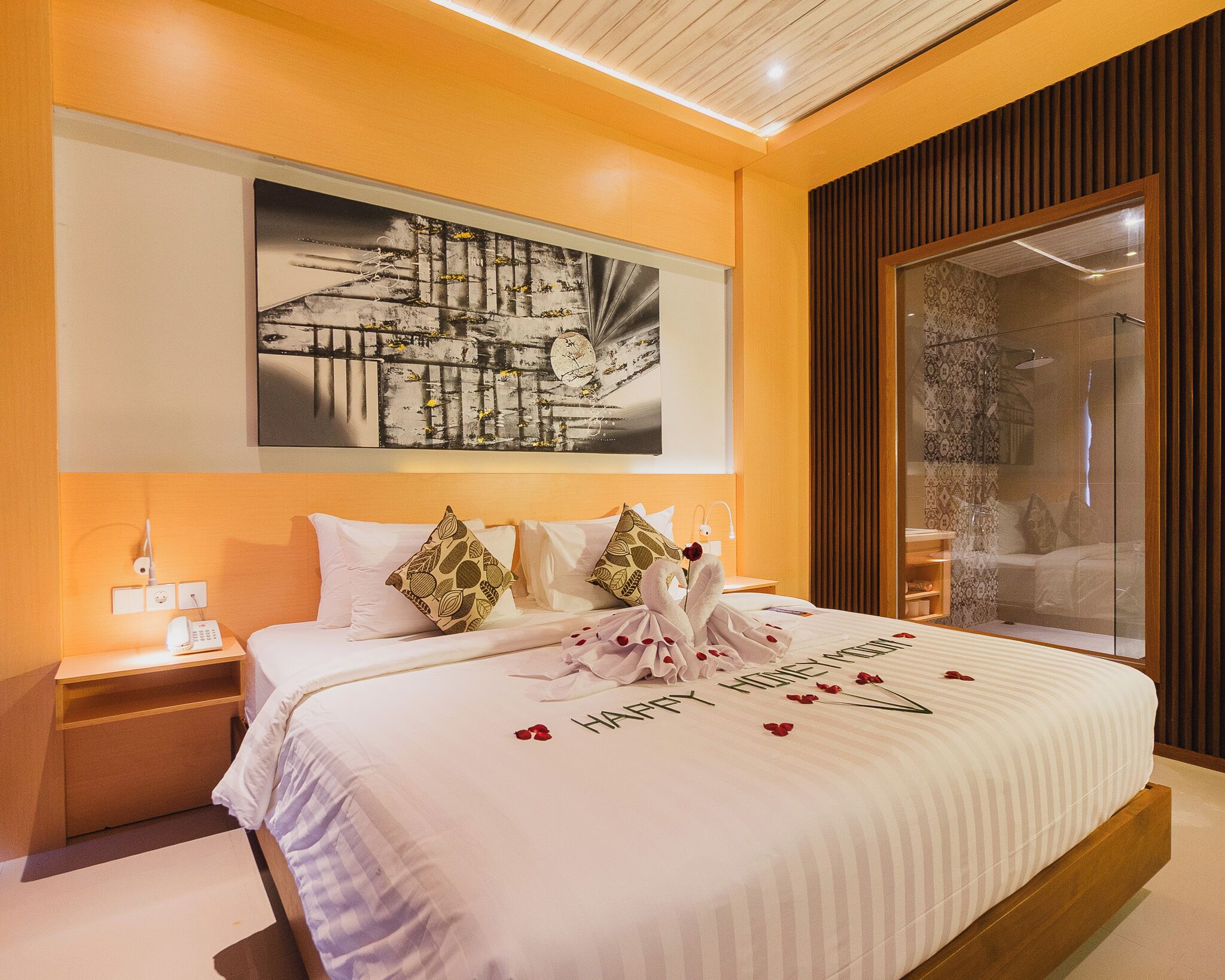 Habitación de hotel con una cama grande, una mesita de noche, un teléfono en la pared y un ventanal con vistas.