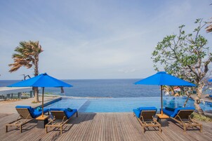 Una piscina al aire libre, sillones reclinables de piscina