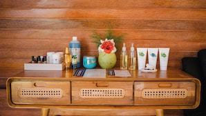 Un escritorio de madera con varios productos para el cuidado de la piel y un jarrón decorativo.