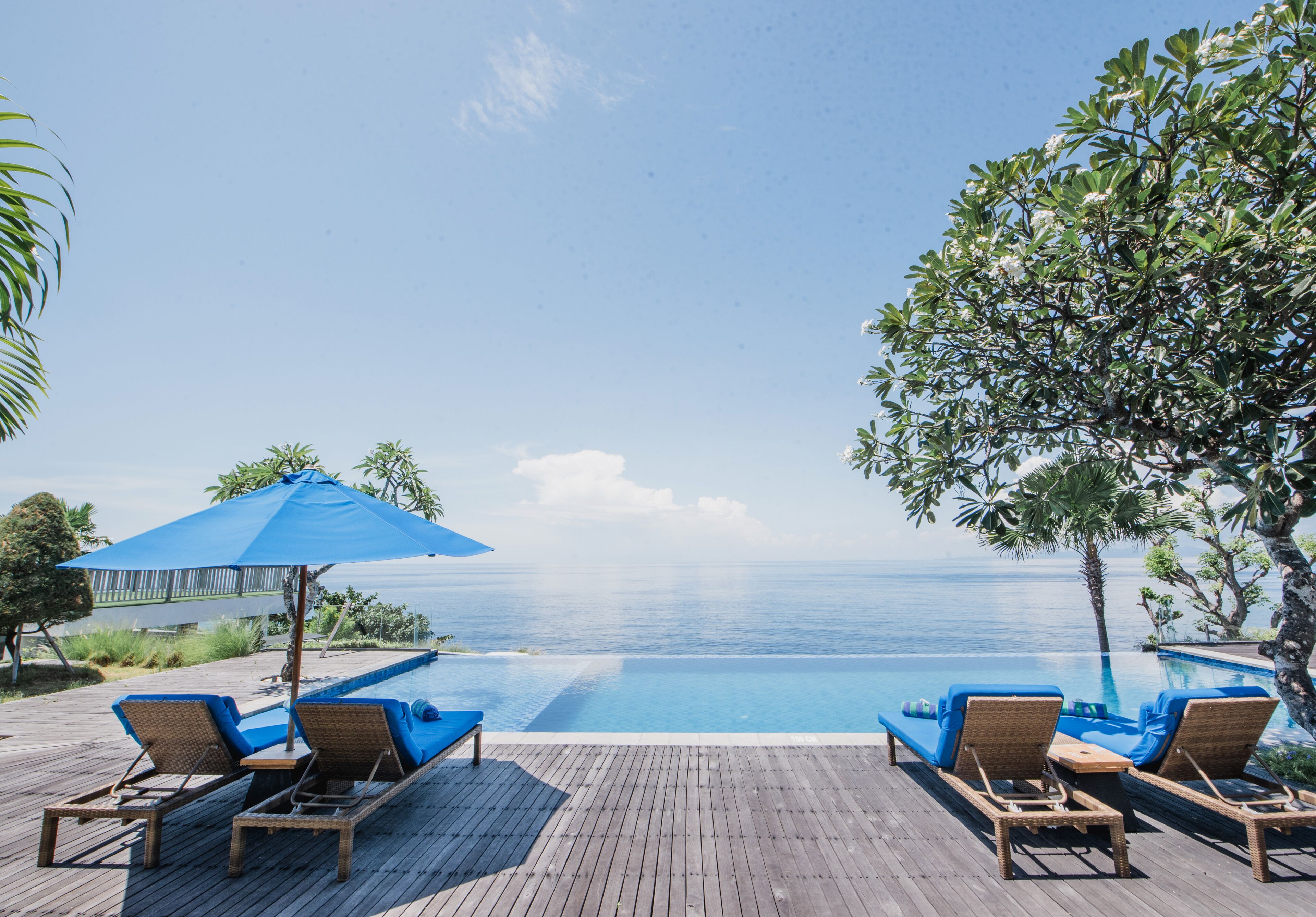 Una piscina al aire libre, sillones reclinables de piscina