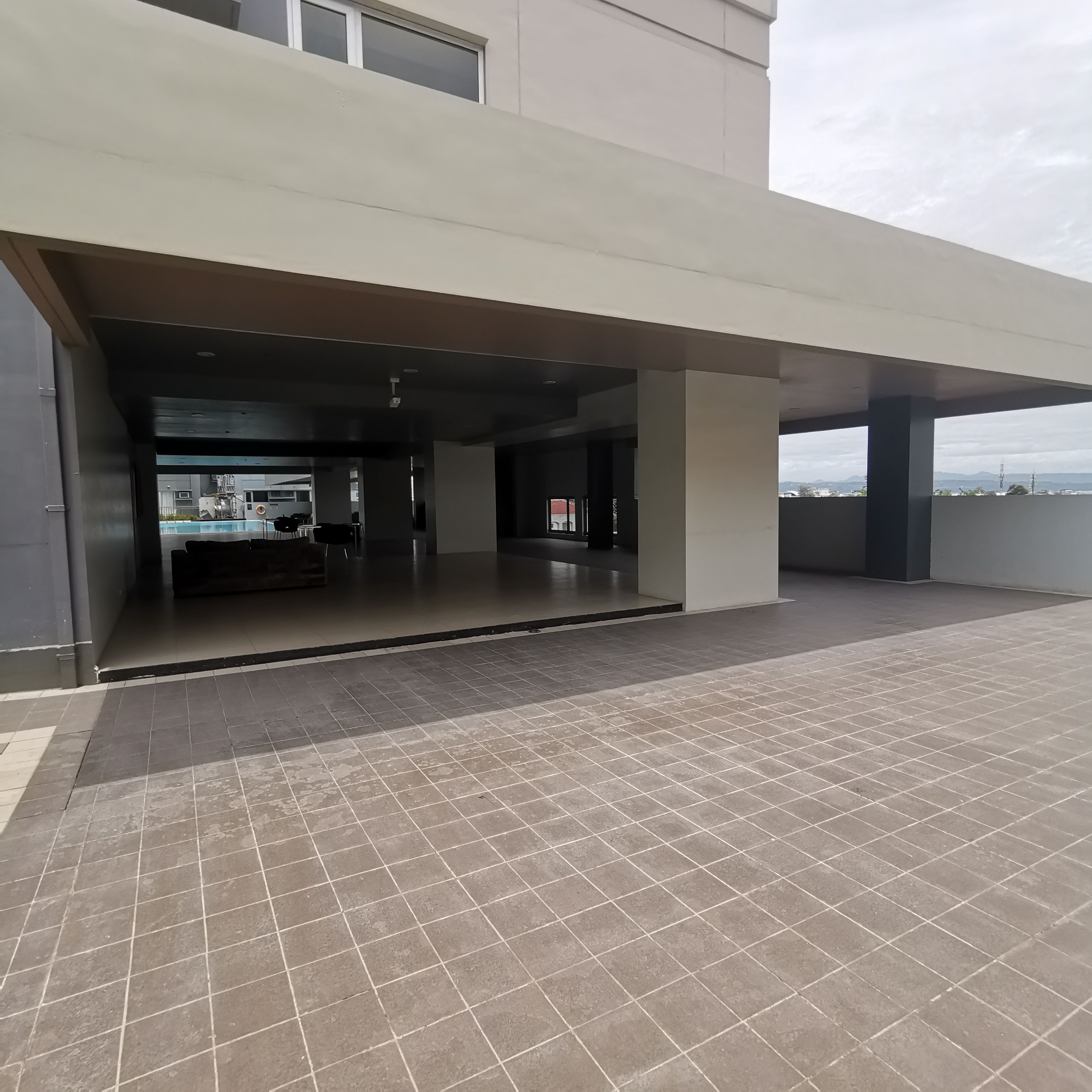 A building entrance with a covered area and a tiled floor.