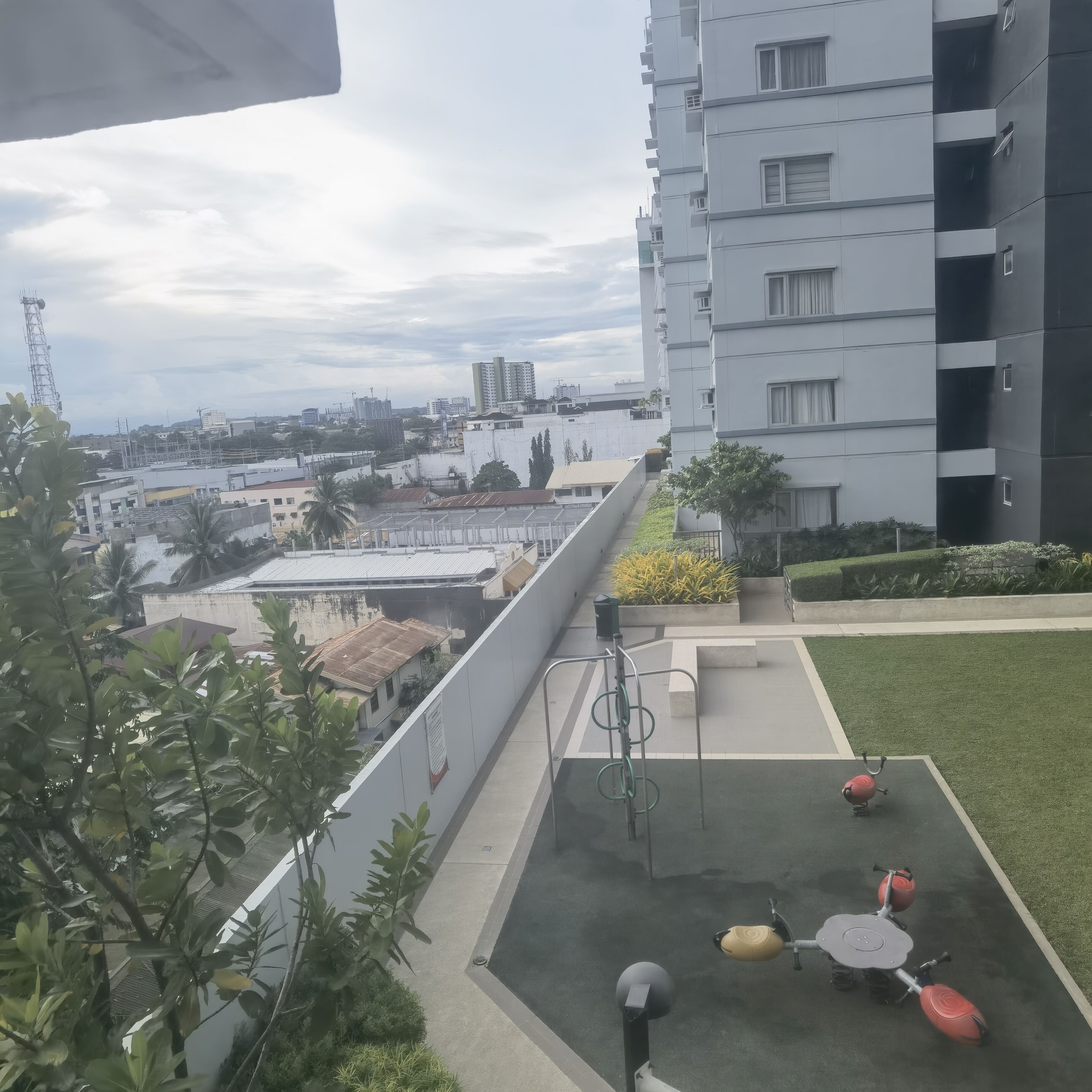 Une terrasse sur le toit offrant une vue sur le paysage urbain, avec les bâtiments et un chantier de construction.