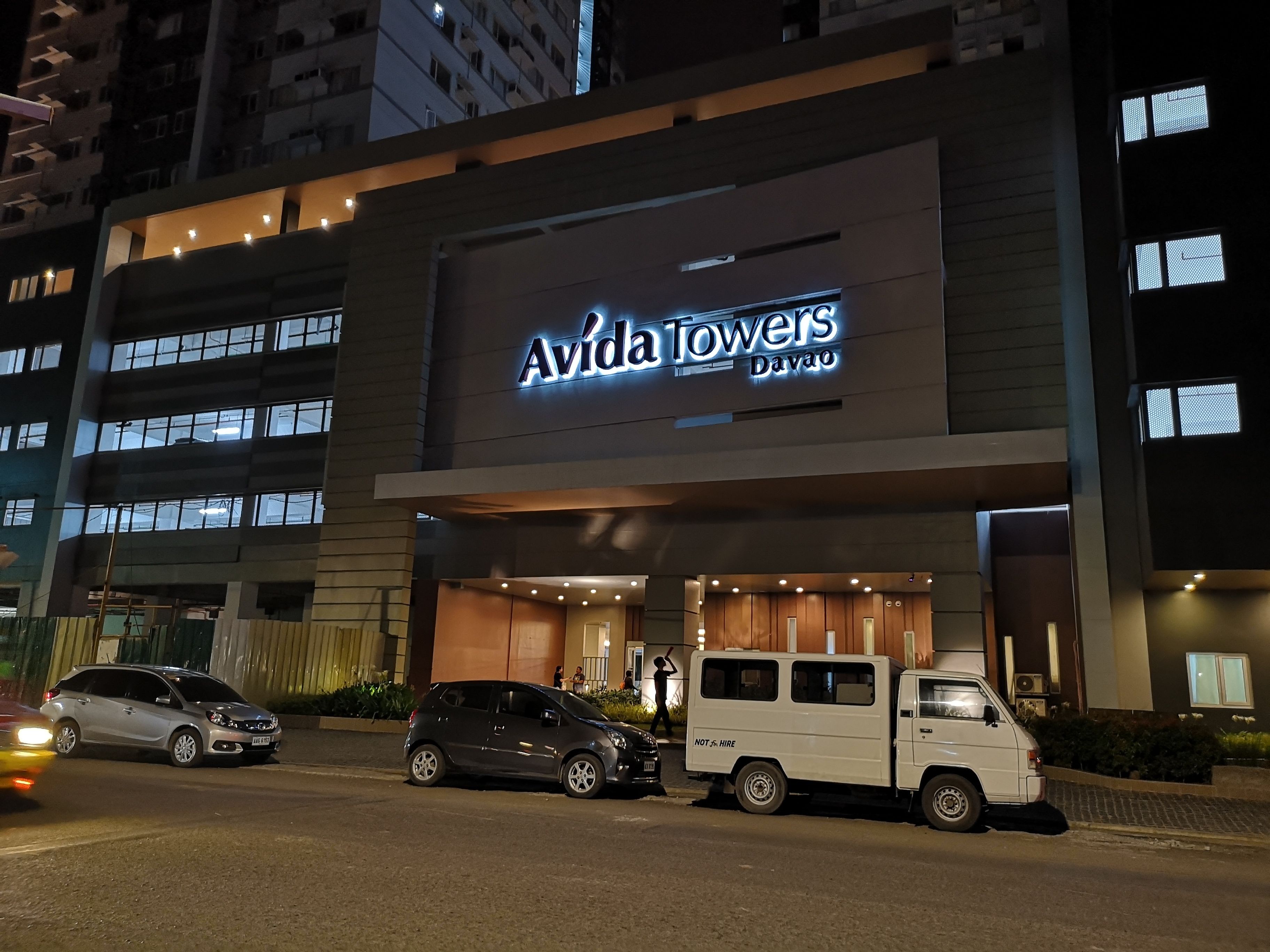 A building with a sign reading "Avida Towers Davao" at night.