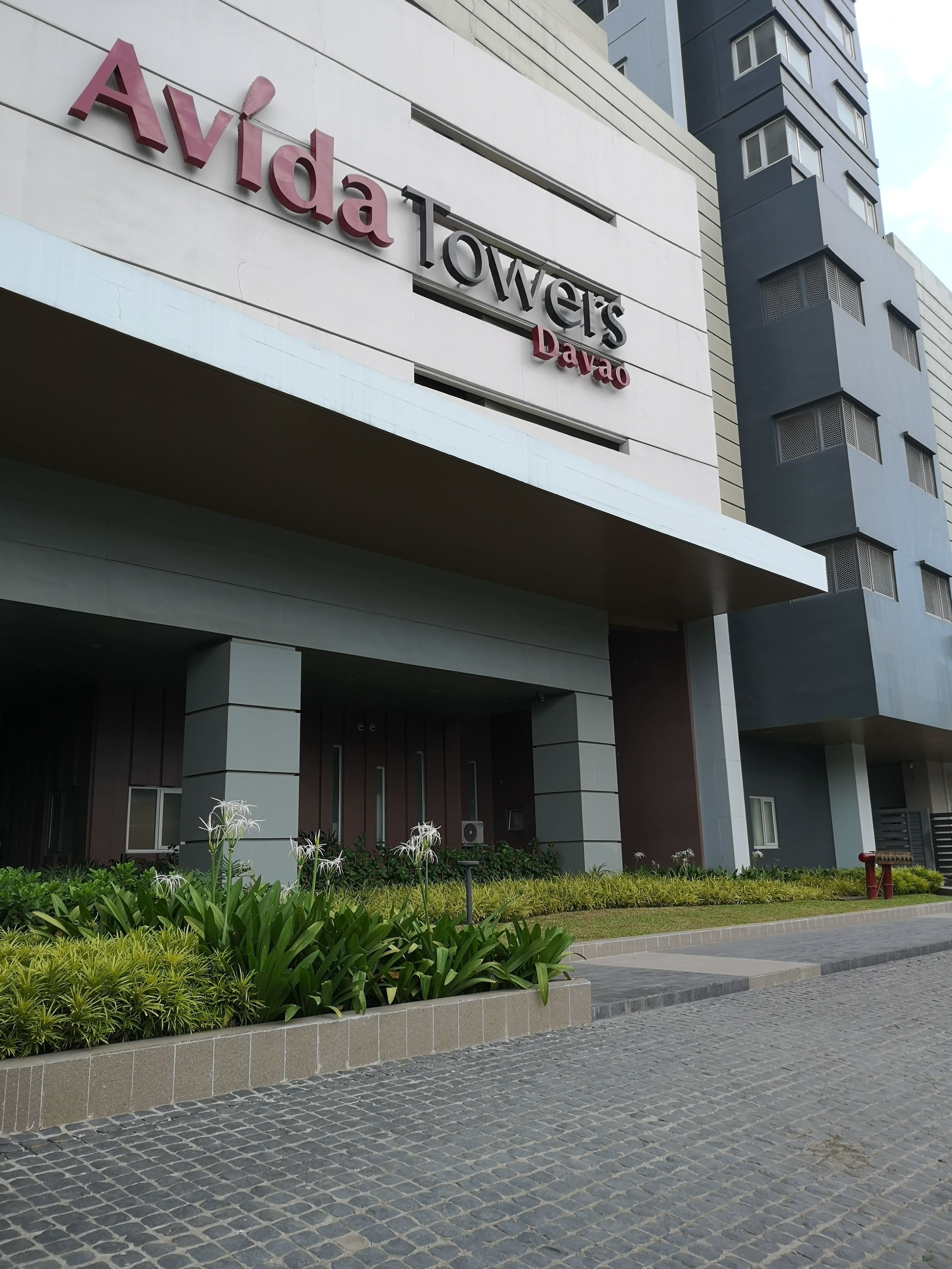 A modern building with the sign "Avida Towers Davao" indicating a hotel or residential complex.