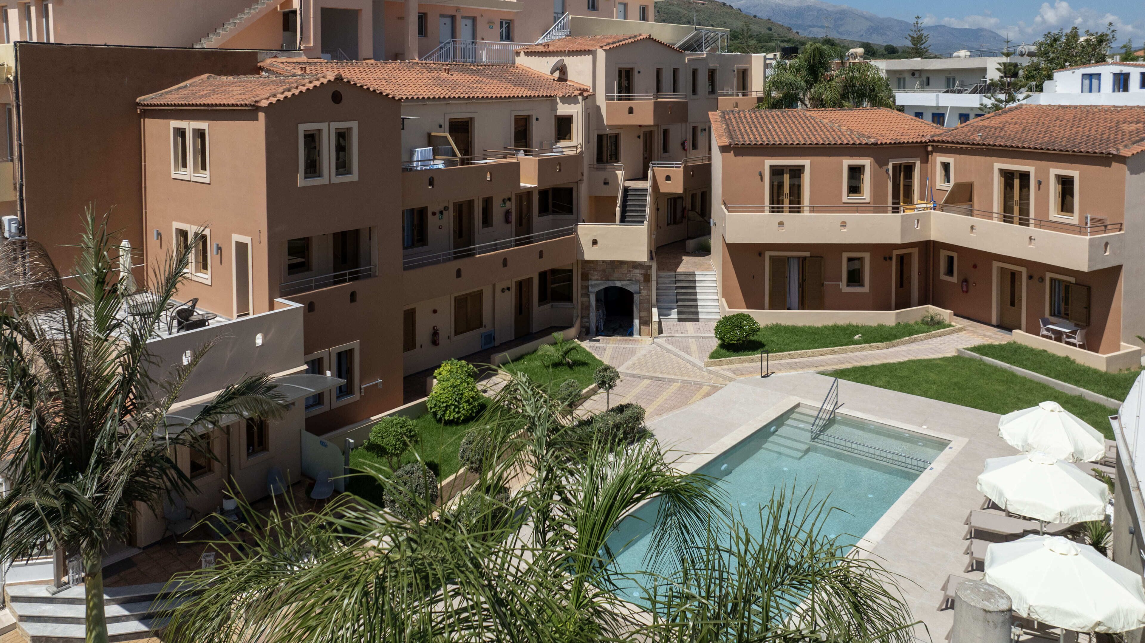 A multi-story residential building with a courtyard, a swimming pool, and outdoor seating.