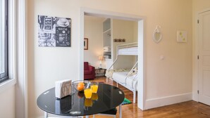 Ein Zimmer mit einem Etagenbett, einem Glastisch mit Orangensaft und einem gerahmten Menü an der Wand.