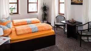 A room with a bed, a table, chairs, a potted plant, and a painting on the wall. - Sefano Seminarfabrik Nossen (Nossen)