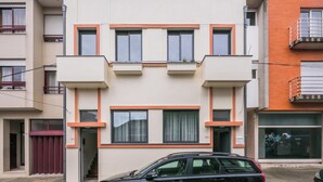 Un bâtiment moderne à deux étages, doté d’un toit plat, de fenêtres rectangulaires et d’un balcon au deuxième étage.