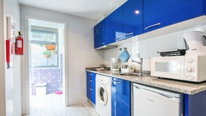 Una cocina moderna con armarios azules, un microondas blanco y una cafetera.