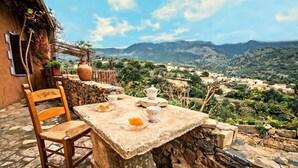 A stone table with a chair on a terrace overlooking a mountainous landscape. - Stone made Mansions (Apokoronas)