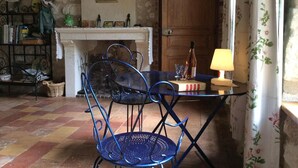 A rustic room with a fireplace, a wooden door, and a table with chairs. - Chambres d'hôtes Côté Jardin (Villiers-sur-Loir)