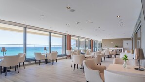 A modern hotel lobby with a large open space, multiple seating areas, and a view of the ocean. - The Level at Melia Alicante - Adults Only (Alicante)