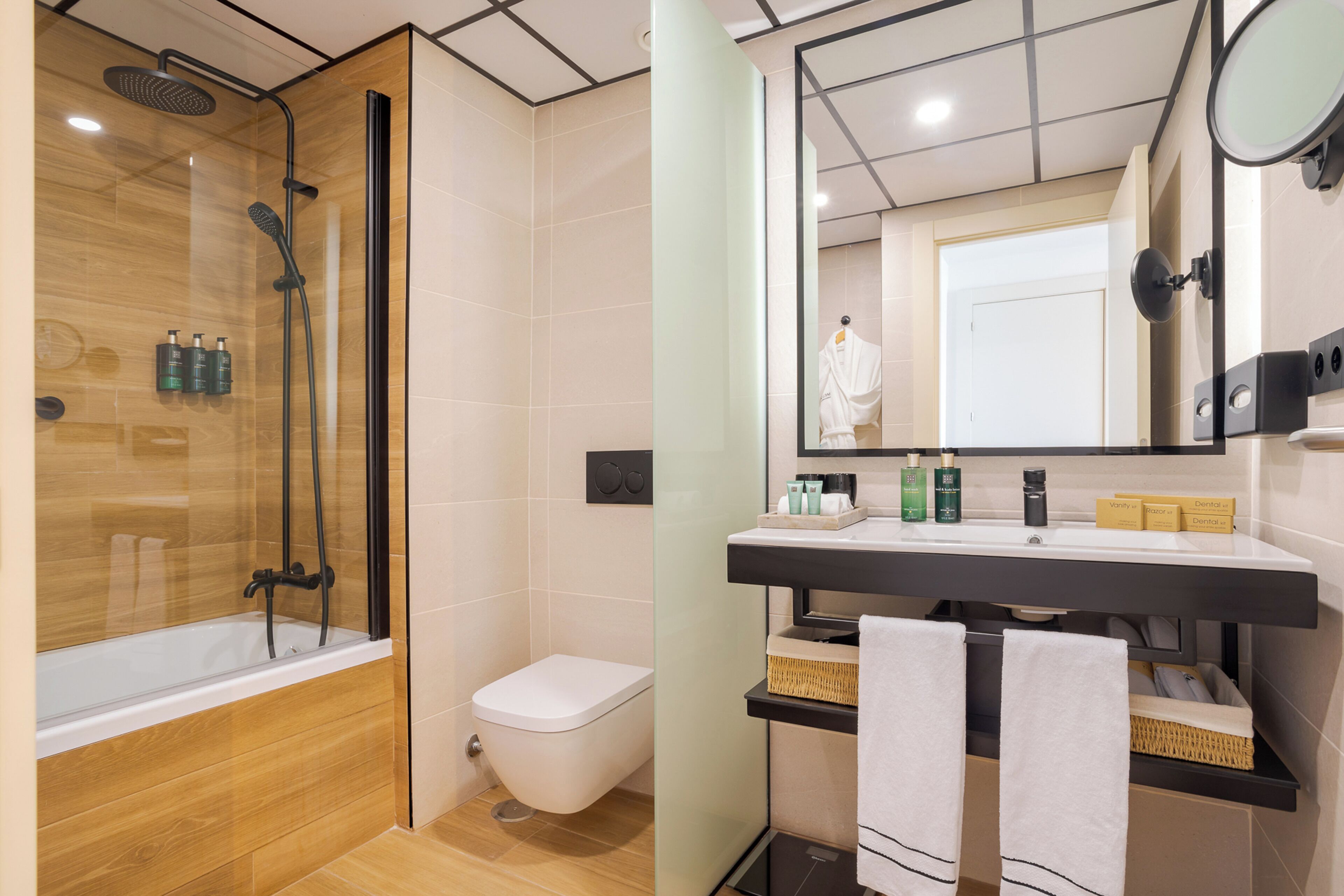 A bathroom with a glass-enclosed shower, a white toilet, and a vanity with a mirror, sink, and towel rack.