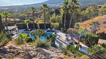 Una piscina al aire libre, sombrillas, tumbonas