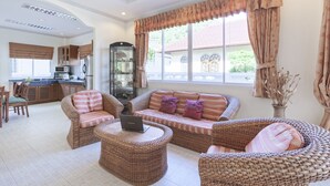 A spacious living area with wicker furniture, a sofa, and a coffee table. - Karon Hill Villa (Karon)