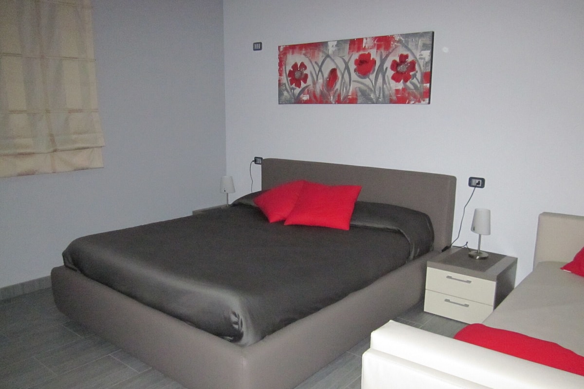 Ein modernes Schlafzimmer mit einem großen Bett, Nachttischen und einem Bild an der Wand.