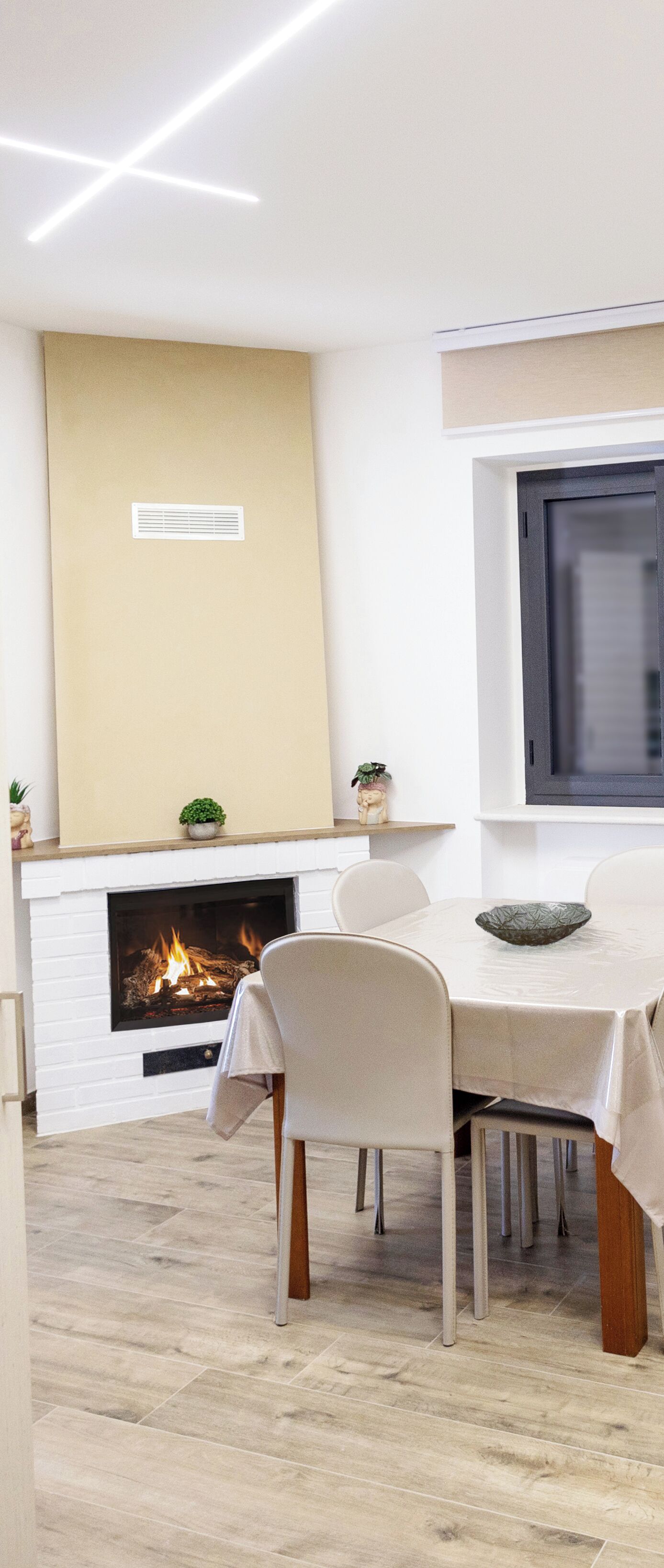 A modern dining area with a fireplace, white walls, and a wooden floor.
