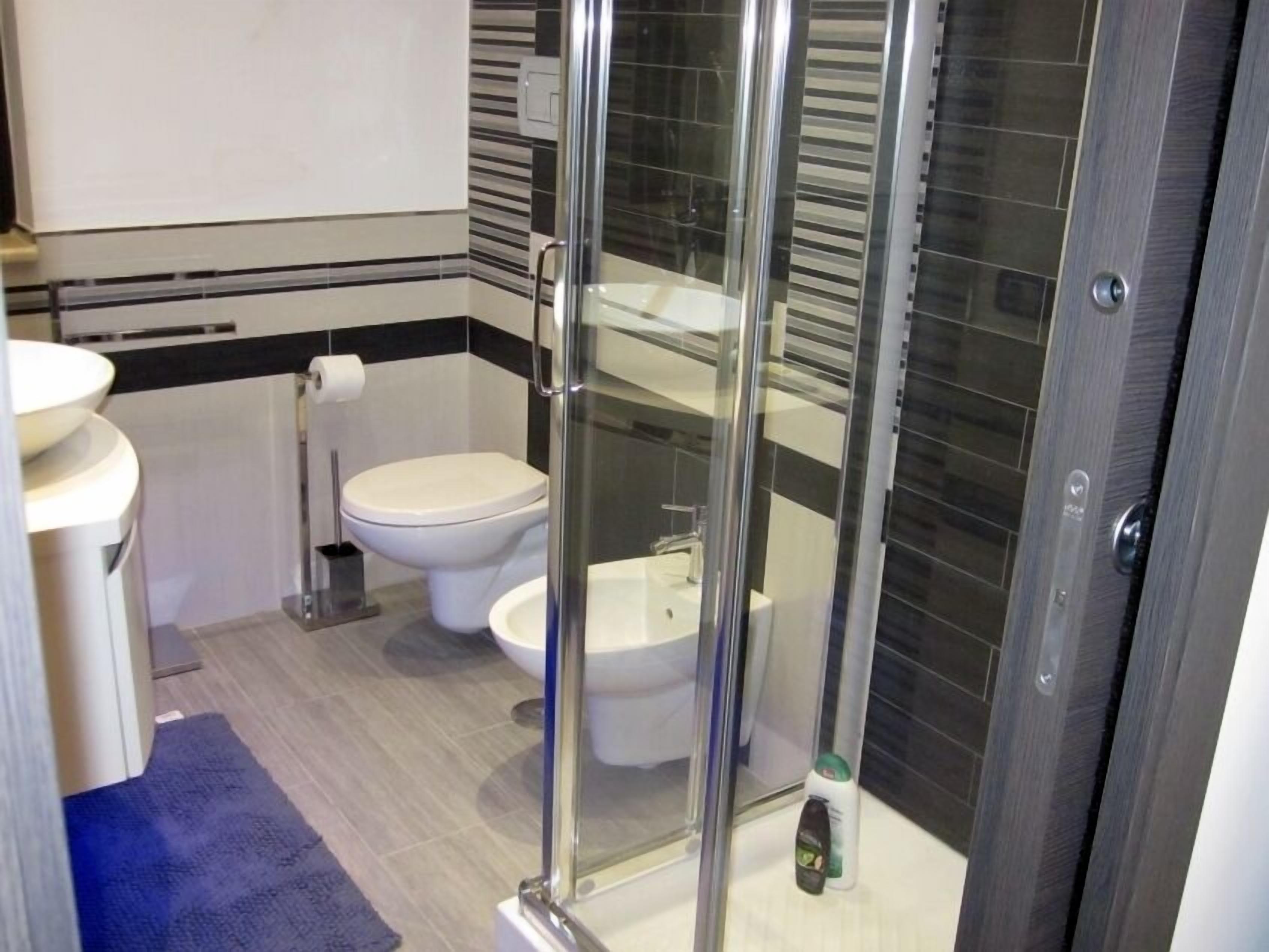 Ein modernes Badezimmer mit einer Duschkabine, einer Toilette und einem Waschbecken.