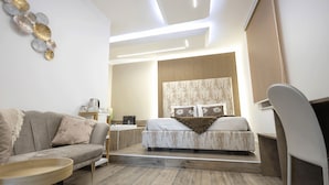 A modern bedroom with a bed, a sofa, a desk, and a chair.