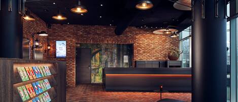Una zona de recepción con pared de ladrillo, suelo de madera en patrón de espiga e iluminación colgante.