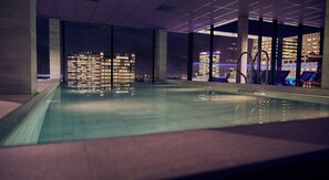 Ein Hallenbad mit Blick auf die Stadt, großen Fenstern und moderner Architektur.
