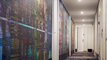 A hallway with a digital art installation on the walls, a carpeted floor, and a white ceiling.