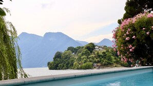 A swimming pool with a view of mountains and a body of water. - Ossuccio Villa Darsena private lakeside villa with pool by Italian Apartments. (Ossuccio)
