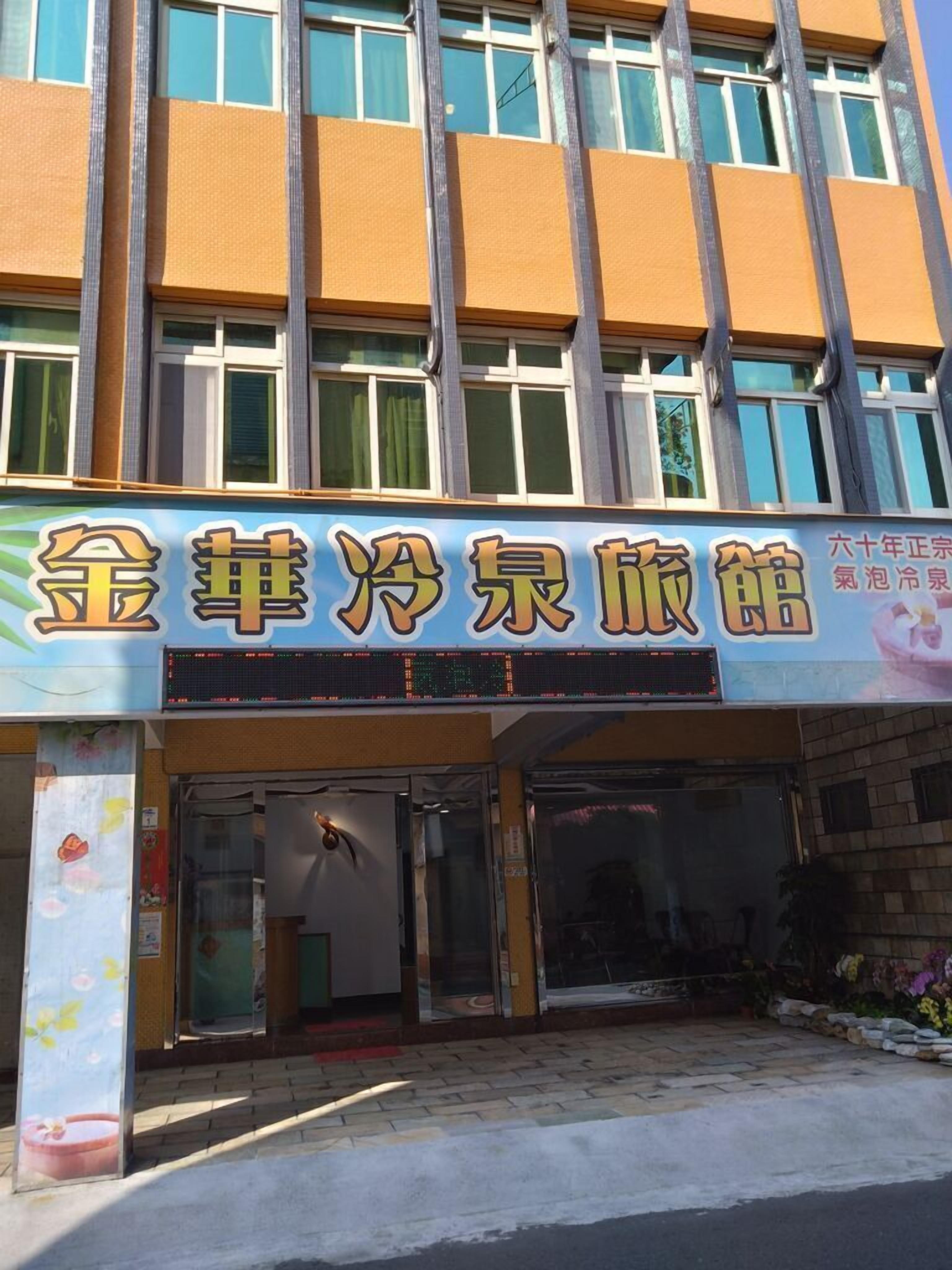 Un edificio con un letrero que dice "金華淨泉旅館" y "六十年正宗氷泡冷泉".