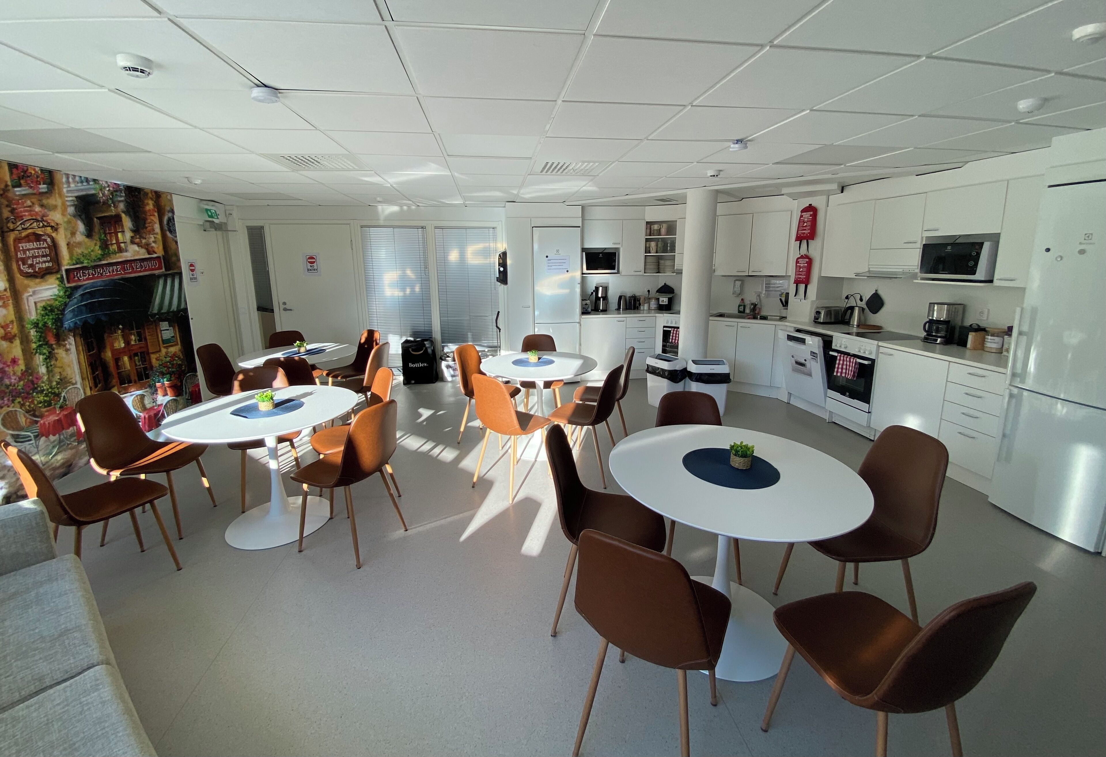 Een moderne hotelkamer met een eethoek, kitchenette en een gezellige zithoek met een bank.