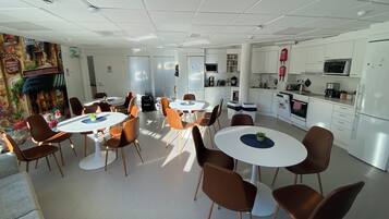 Een moderne hotelkamer met een eethoek, kitchenette en een gezellige zithoek met een bank.