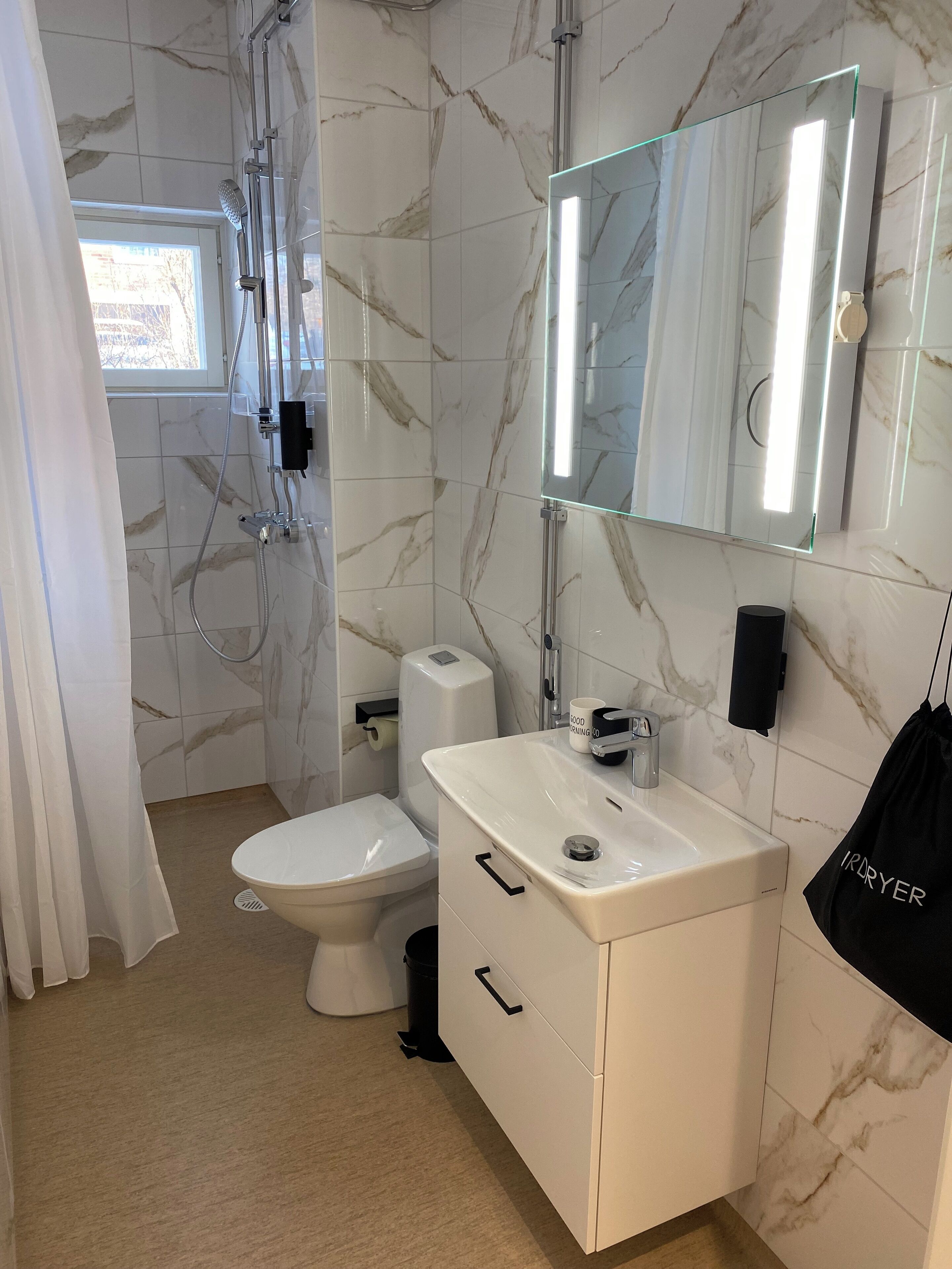 A bathroom with a shower, toilet, and vanity with a mirror.