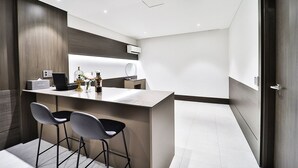 Una cucina moderna con isola centrale, sgabelli da bar e forno integrato.