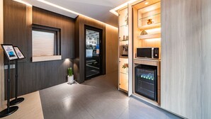 Una cucina moderna con elettrodomestici integrati, un piccolo frigorifero e un forno a microonde.