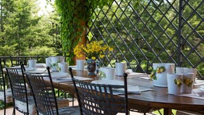 A wooden table set for dining with white plates, cups, and a vase with yellow flowers. - Domus Sicily - Fattoria Gorgo - Contessa Entellina (Abbazia di Santa Maria del Bosco)