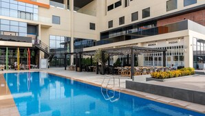 Un hôtel moderne doté d’une piscine, d’un espace extérieur aménagé et d’un restaurant.